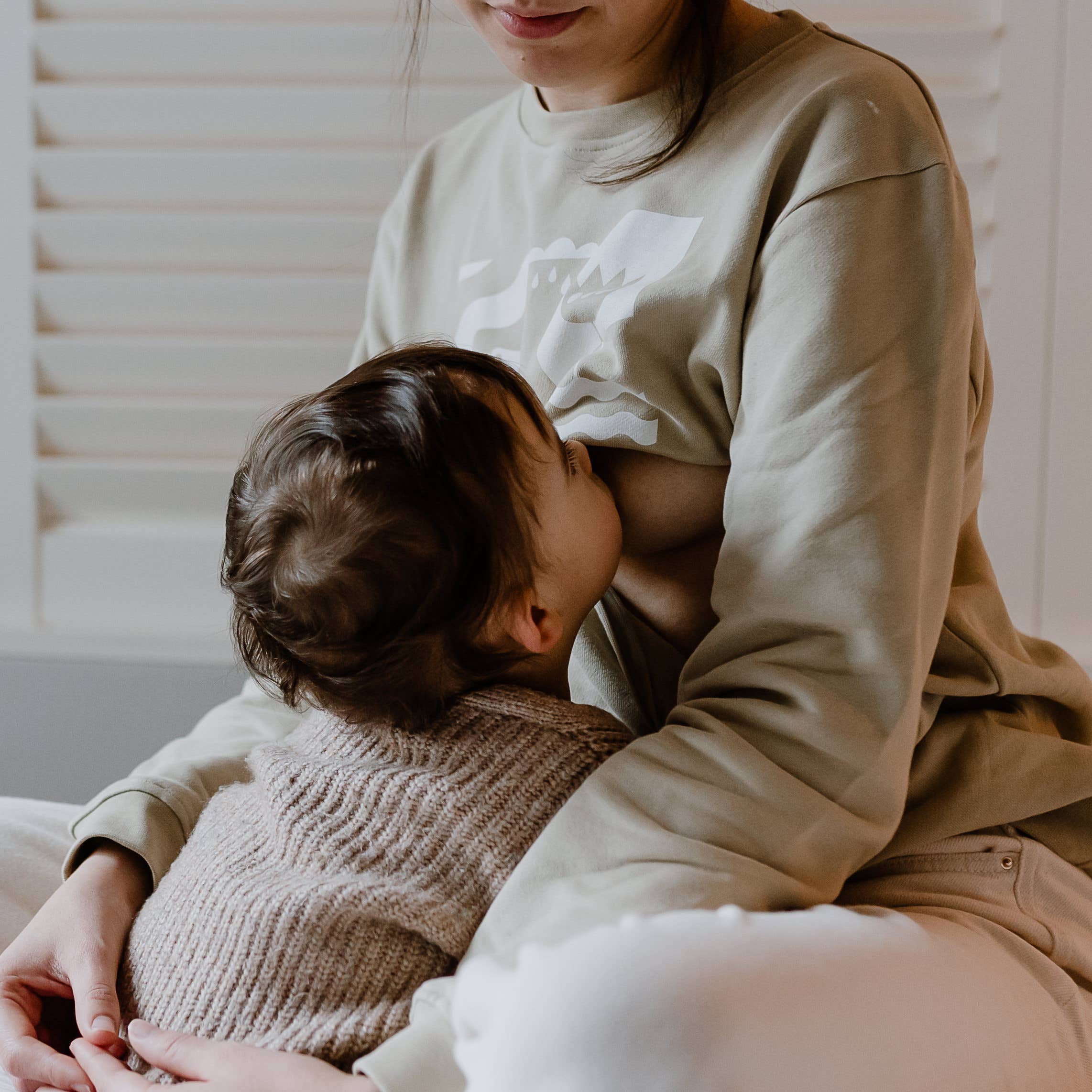 stillende-frau-im-sitzen-mit-still-pullover-mit-reissverschluss-dazwischen-freiburg